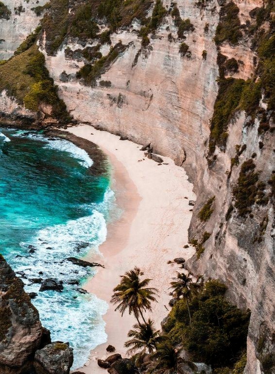 A white beach below tall cliffs