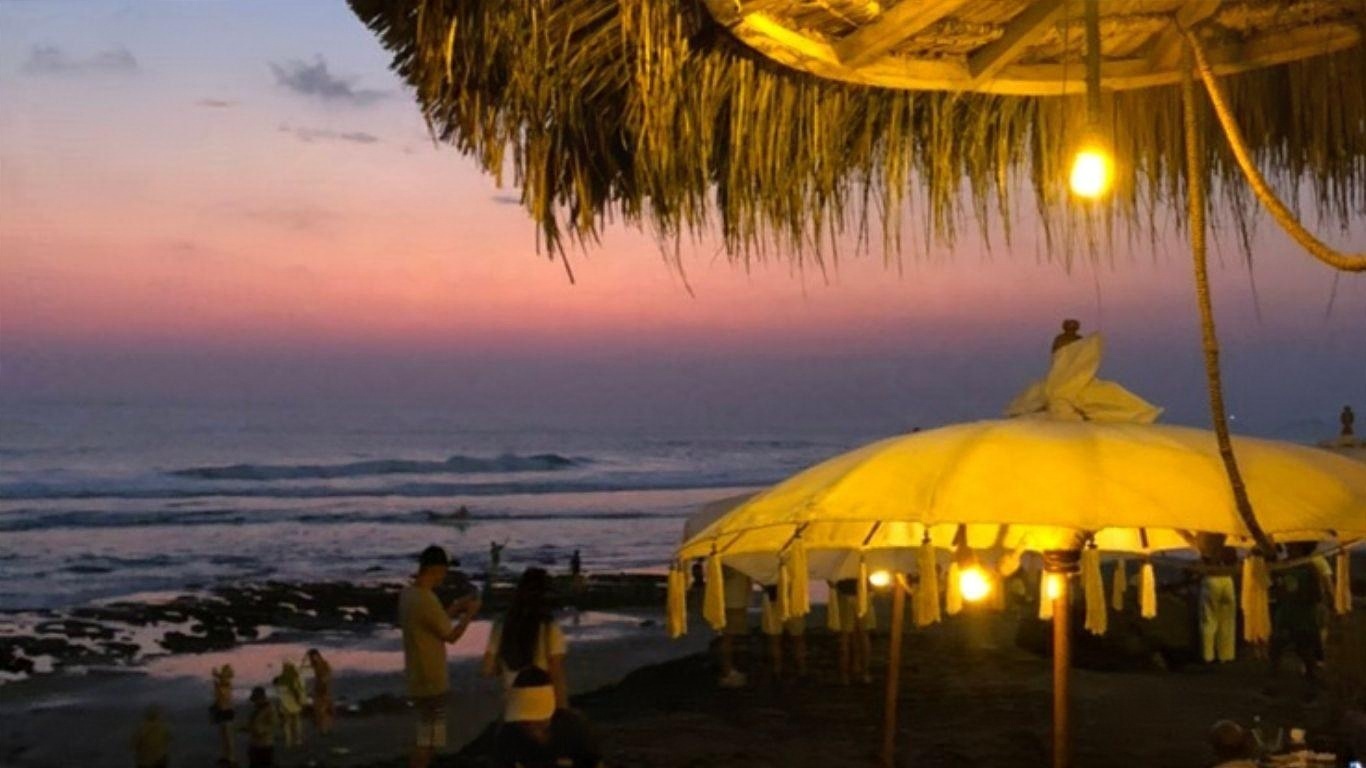 A beach restaurant lit at dusk